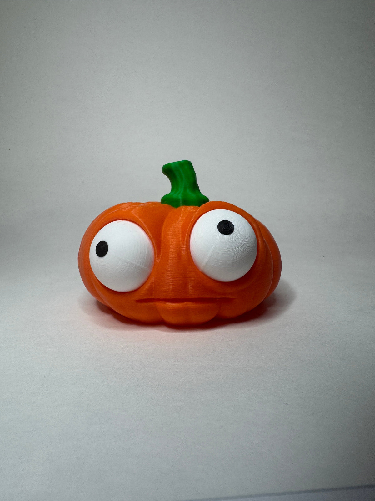 Orange Goofy Pumpkins with green stems and posable eyes, wide shape